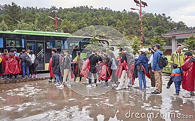 Tourists wait in line for a bus in Blue Moon Valley scenic area on a rainy day. Editorial Stock Photo