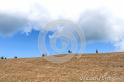 Tourists walk on the sand near the Rubjerg Knude Lighthouse on the coast of the North Sea in the Jutland in northern Editorial Stock Photo