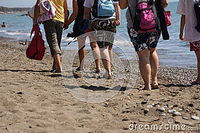 Tourists walking on beach Stock Photo