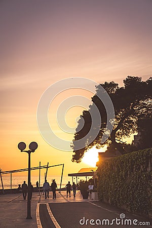 Tourists walking on a seaside promenade at dusk Editorial Stock Photo