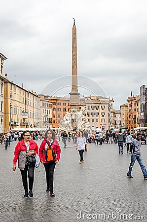 Tourists walking on the tour of the monument near the fountain with a marble sculpture on the Piazza Navona in Rome, capital of I Editorial Stock Photo