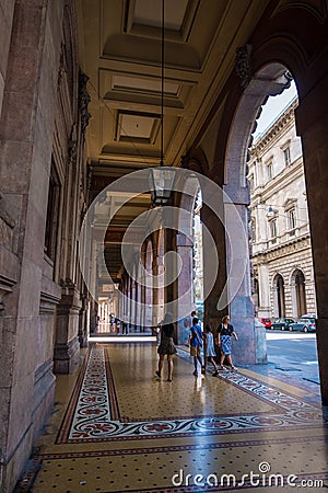 Tourists walking under the arches of Via XX Setembre, the main boulevard in Genoa Editorial Stock Photo