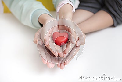 Tow child holding red heart, closeup. Adoption concept Stock Photo