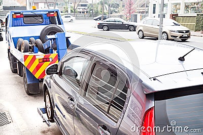 Tow truck towing a broken down car on the street Stock Photo