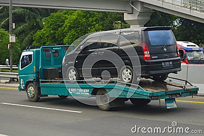 Tow truck (Mitsubishi Canter towing a Nissan Serena C24) Editorial Stock Photo