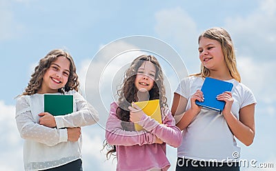 Towards knowledge. School students learning literature. kids reading books. three girls writing in notebook. back to Stock Photo