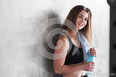 With towel and bottle of water. Photo of gorgeous blonde woman in the gym at her weekend time Stock Photo