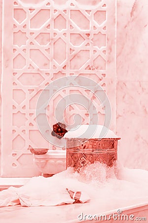 Towel and copper bowl with soap foam in turkish hamam. Traditional interior details . Living coral theme - color of the year 2019 Stock Photo