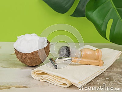 A towel with shaving accessories and a bowl with coconut foam Stock Photo