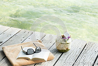 Towel sunglasses book longdrink on pier Koh Samui Thailand Stock Photo