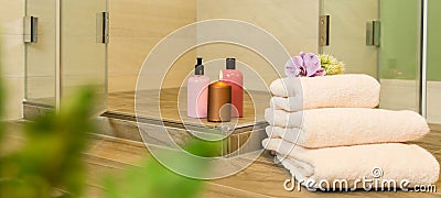 Towels and perfumed lotions in the bathroom with a candle Stock Photo