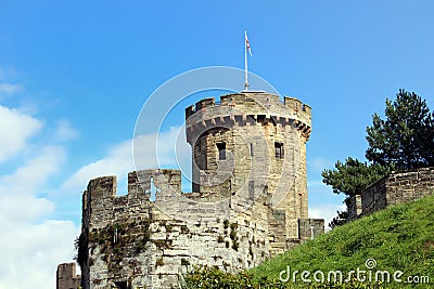 Tower and battlements of a medieval English castle on a grassy m Stock Photo