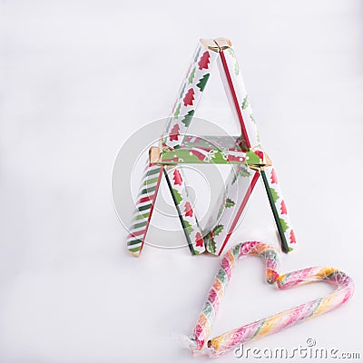 Tower of colorful chocolates and candy canes drawing a heart shape Stock Photo
