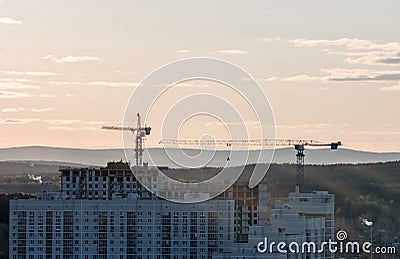 Tower crane against the sky in the afternoon. Backlight. Ekaterinburg, Russia.. Stock Photo