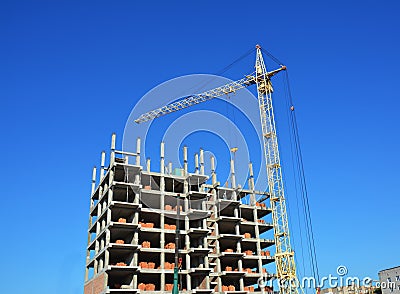 Tower Crane and Building Constructors on Construction Site. Building cranes on construction site with builders. Building high rise Stock Photo