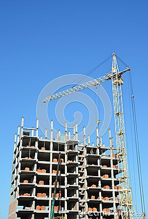 Tower Crane and Building Constructors on Construction Site. Building with two cranes on construction site with builders. Stock Photo