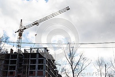 Tower crane builds a new house from a monolithic frame and a monolithic brick structure Stock Photo