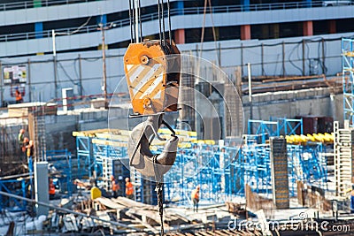 Tower crane lifting hook detail against the construction of a large commercial building. Stock Photo