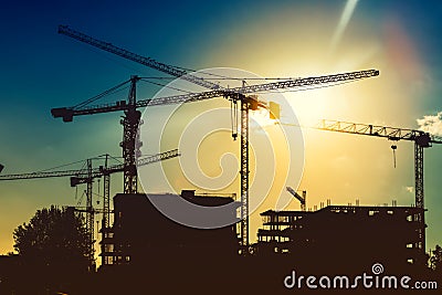 tower cranes on industrial construction site. New district development and skyscraper building Stock Photo