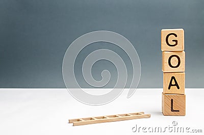 tower of cubes with an inscription goal and a fallen ladder. The concept of achieving the goal Stock Photo