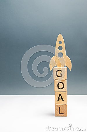 Tower of cubes with the word goal and rocket on top. overcoming obstacles and thinking extraordinarily. Startup and crowdfunding. Stock Photo
