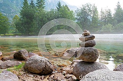 Tower of rocks by the beautiful calm river of Soca Stock Photo