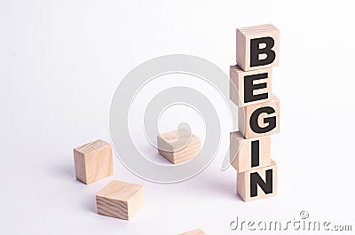 A tower of squares and cubes on a white background with the inscription begin. The beginning of something new Stock Photo