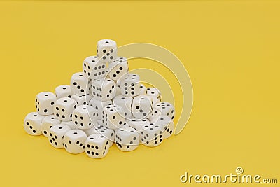 Tower of white game cubes on the left with yellow background Stock Photo