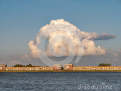 Towering cumulonimbus cloud over apartments on IJsselmeerdijk in Lelystad, Netherlands Stock Photo