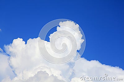 Towering white cumulus cloud into rich blue sky Stock Photo