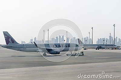 Towing Qatar aircraft to the parking lot by TUG Pushback tractor. Editorial Stock Photo