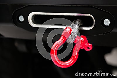 A towing winch with a clevis and a loop on a metal cable mounted on a car for pulling out and evacuating vehicles. Overcoming off- Stock Photo