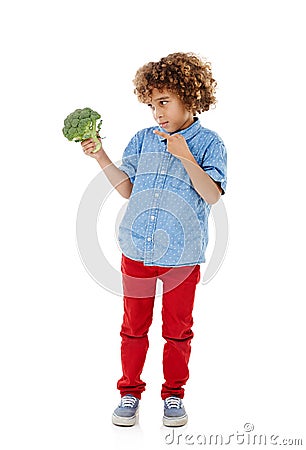 This town aint big enough for the both of us. Studio shot of a cute little boy pointing to broccoli against a white Stock Photo