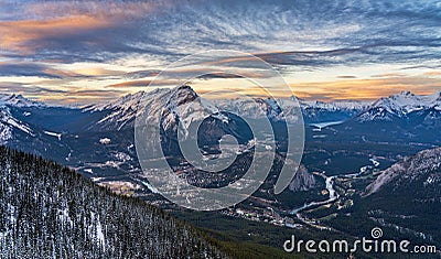 Town of Banff in winter dusk. Sky of colorful rosy clouds. Canadian Rockie. Banff National Park Stock Photo
