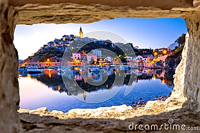 Town of Vrbnik harbor view morning glow view through stone window Stock Photo