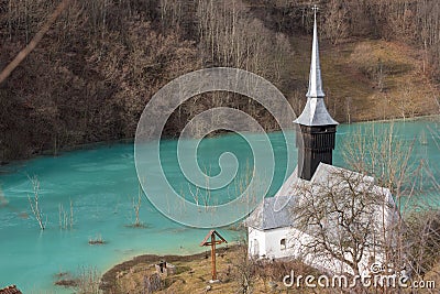 Toxic waste waters from a copper and gold mine submerge village. Abandoned orthodox church on lakeside Stock Photo