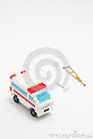 Toy ambulance car, miniature drop, gibbs, and crutch on white background. Stock Photo