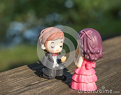 A toy bridegroom makes a proposal of marriage to his girl Stock Photo