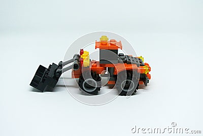 Toy bulldozer made from mostly orange and black plastic bricks. Stock Photo