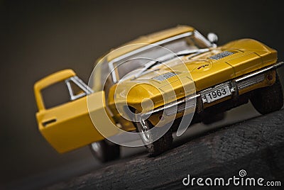 Toy car model Corvette Sting Ray 1963 year. Yellow color. Front view. Opened door. Close-up. Macro. Editorial Stock Photo