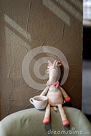 Toy on the chair in coffee house cafe with cup of alternative black filter coffee pour over Stock Photo