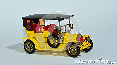 Toy diecast model of a Yellow 1907 Peugeot a Matchbox yesteryear product by Lesney with white background Editorial Stock Photo