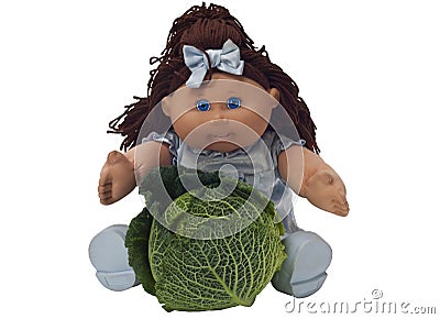 Toy doll sitting behind a cabbage Editorial Stock Photo