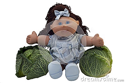 Toy doll sitting between two cabbages Editorial Stock Photo