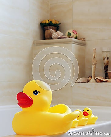 Toy ducks for bathing small children standing on the edge of the bathtub Stock Photo