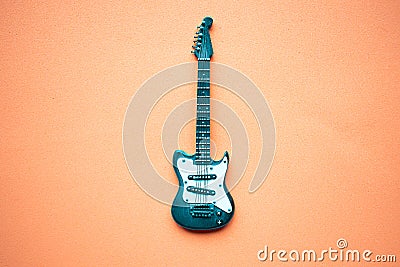 Toy electric guitar on pastel pink background. Stock Photo