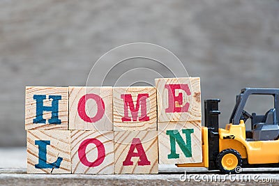 Toy forklift hold letter block E and N to complete word home loan Stock Photo