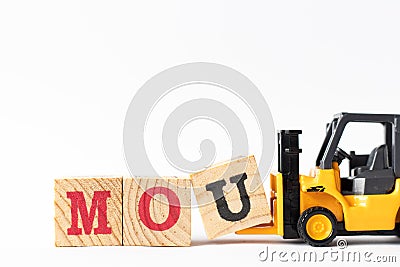 Toy forklift hold wood block U to complete word MOU Abbreviation of memorandum of understanding on white background Stock Photo