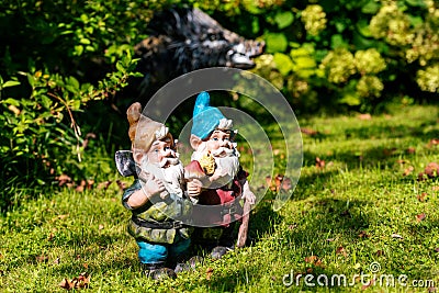 Toy garden gnomes on a sunny green lawn. Selective focus Stock Photo