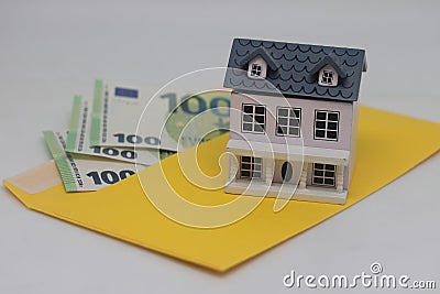 Toy house. banknotes in a yellow envelope on a light background. envelope with banknotes. close-up of an envelope with Stock Photo